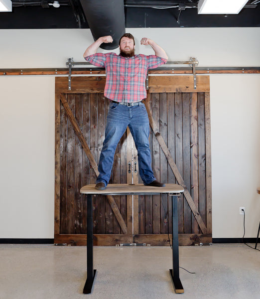 Max Lift 300 pounds - Large Man Shown on Top of Standing Desk